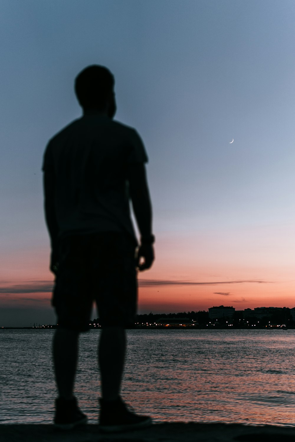 silhouette of person standing near body of water