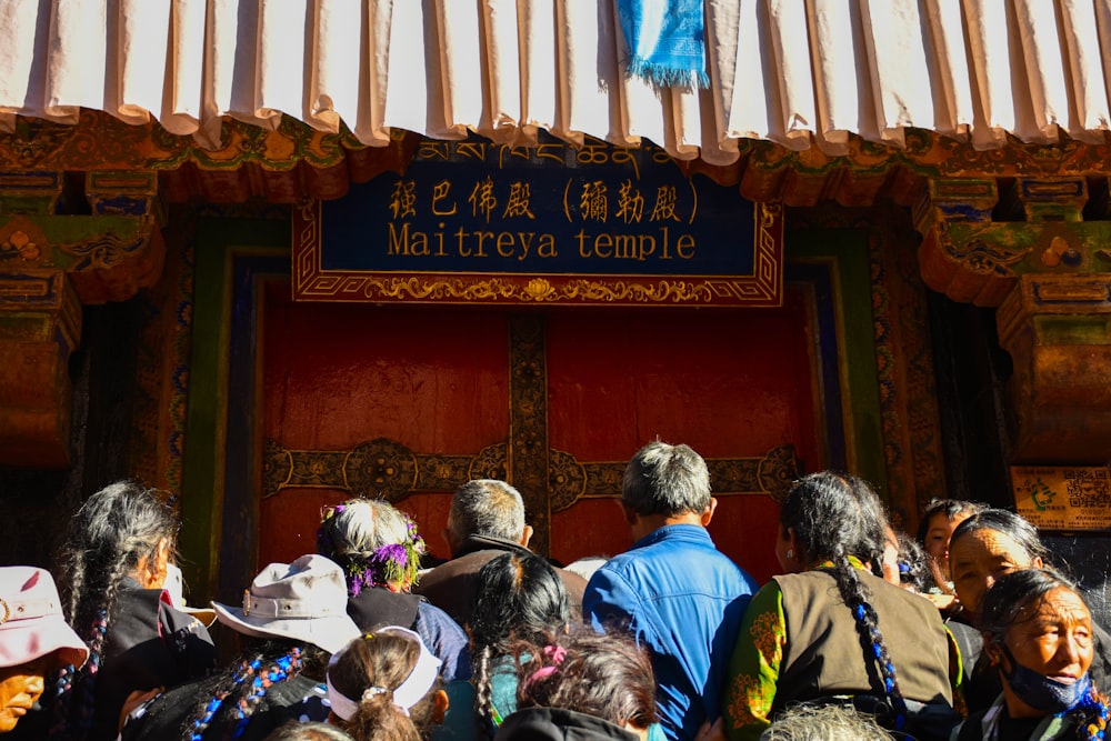 people gathering on front of Maitreya temple sign