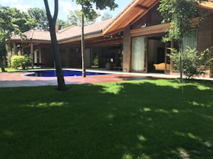 A sleek, modern small home pod nestled in a lush garden setting.