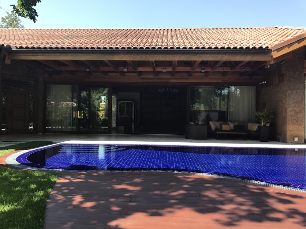 brown house with pool at daytime