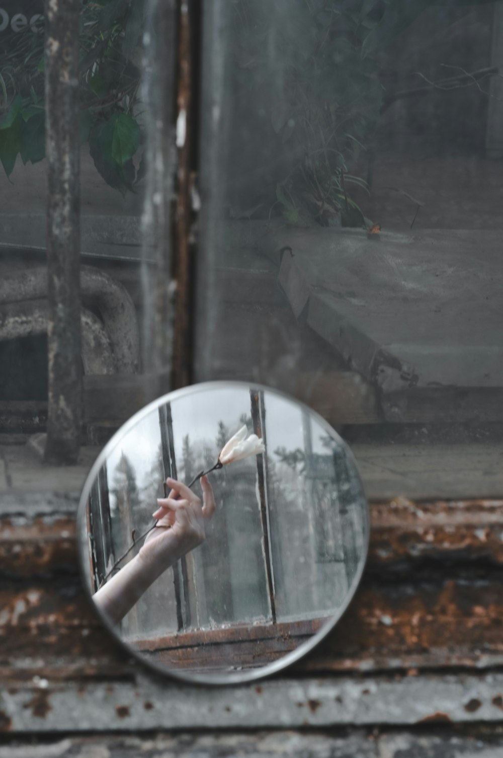 round leaner mirror with reflection of woman holding white flower