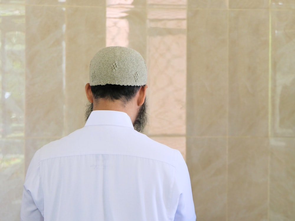 Muslim man wearing traditional dress pictured from back