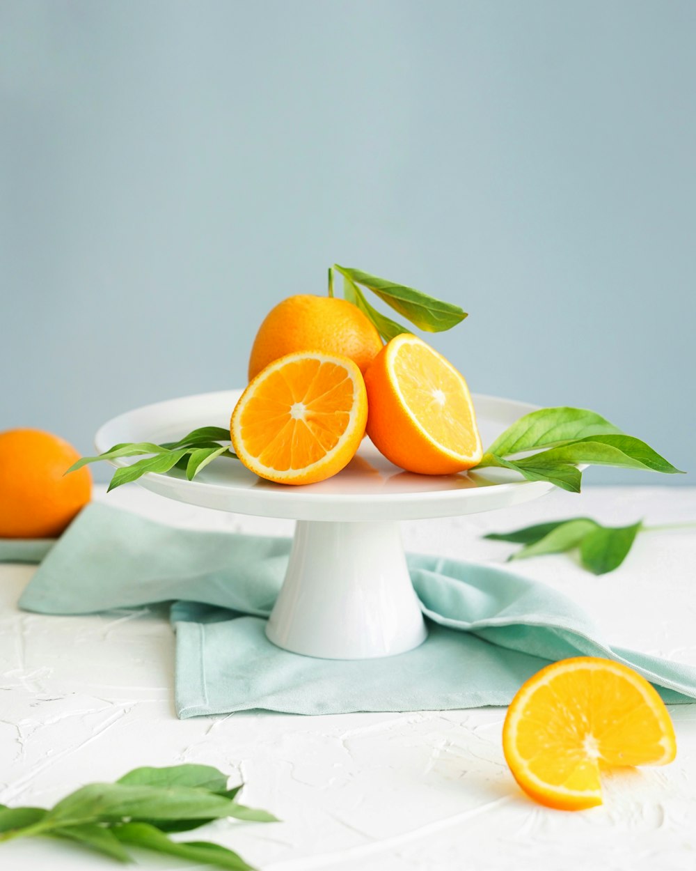 fotografía de primer plano de fruta naranja en placa de cerámica blanca