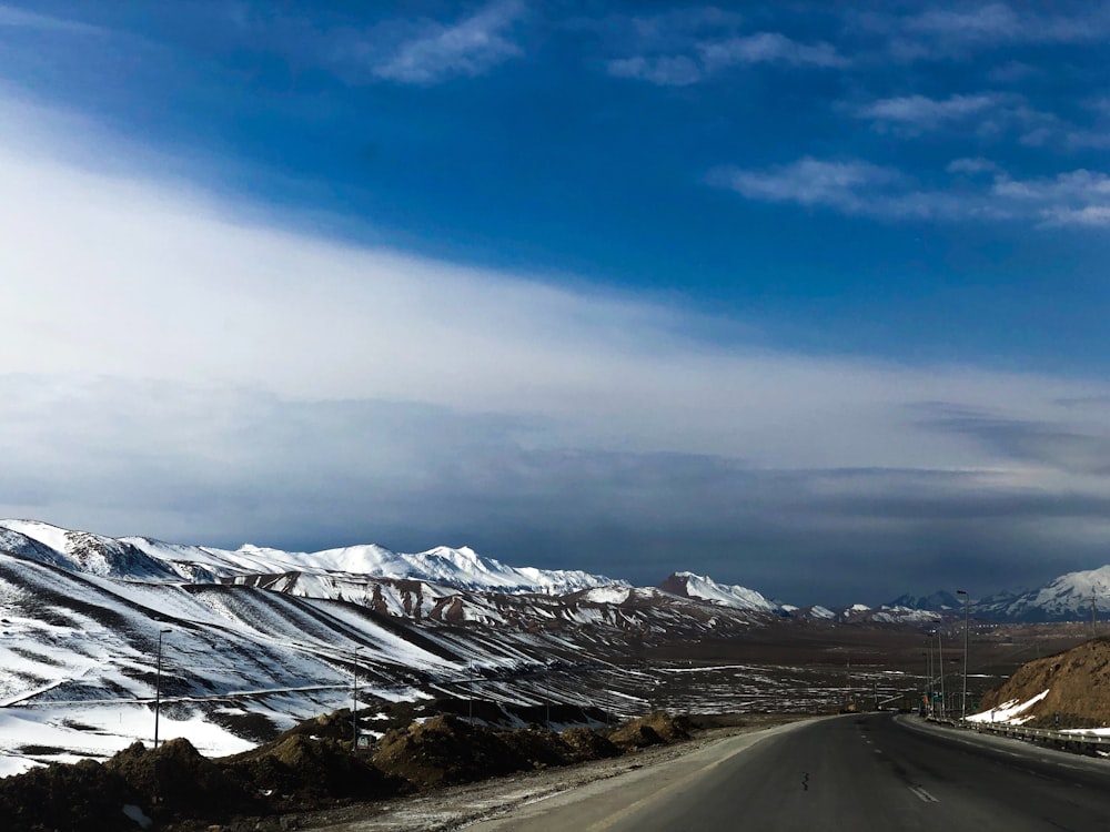 icy mountain and gray asphalt road