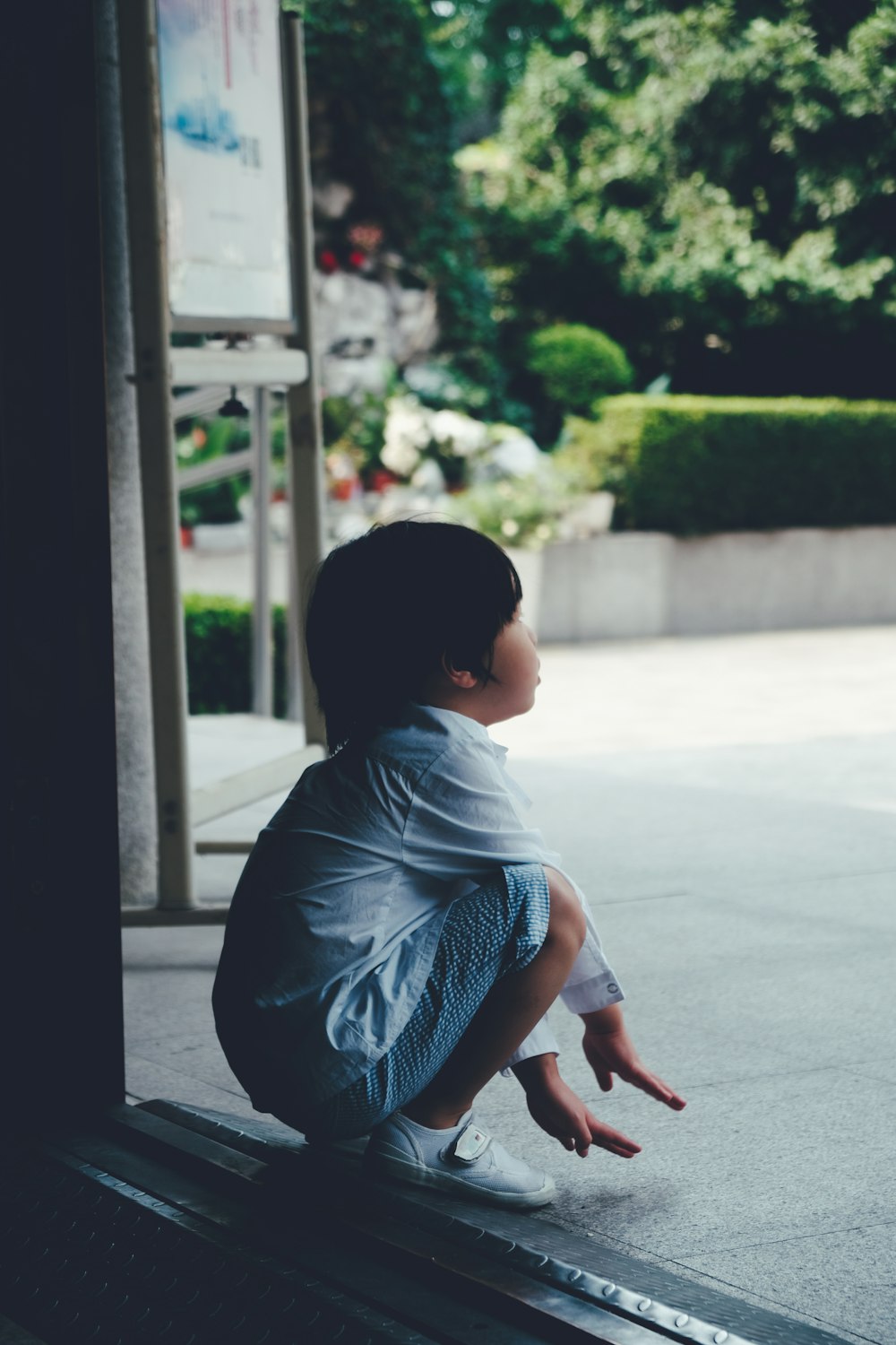 kid sitting on a bench during daytime