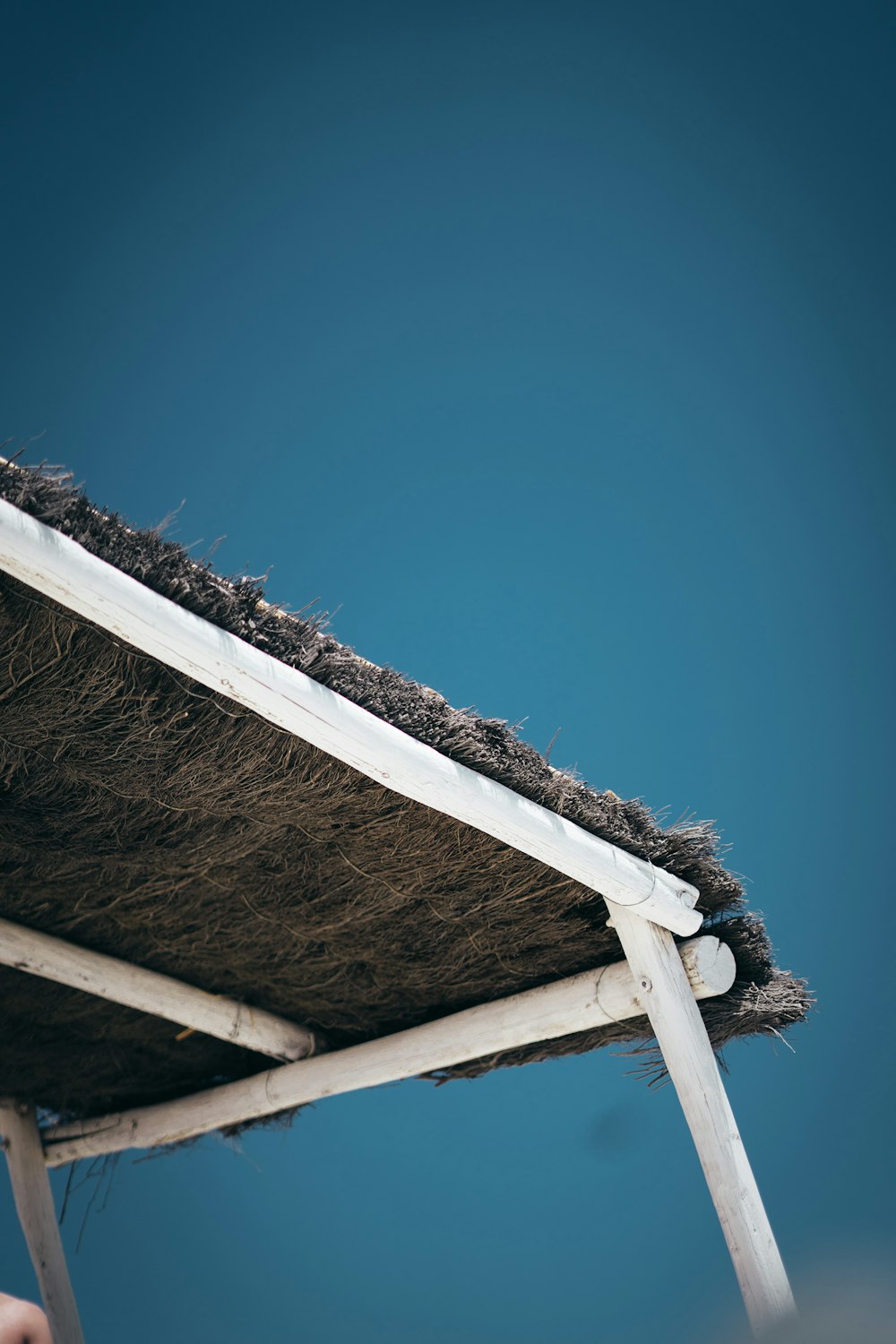 a close up of a wooden structure with a thatch roof