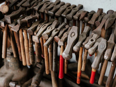 Manganese steel shredder hammers arranged neatly on a workshop table.