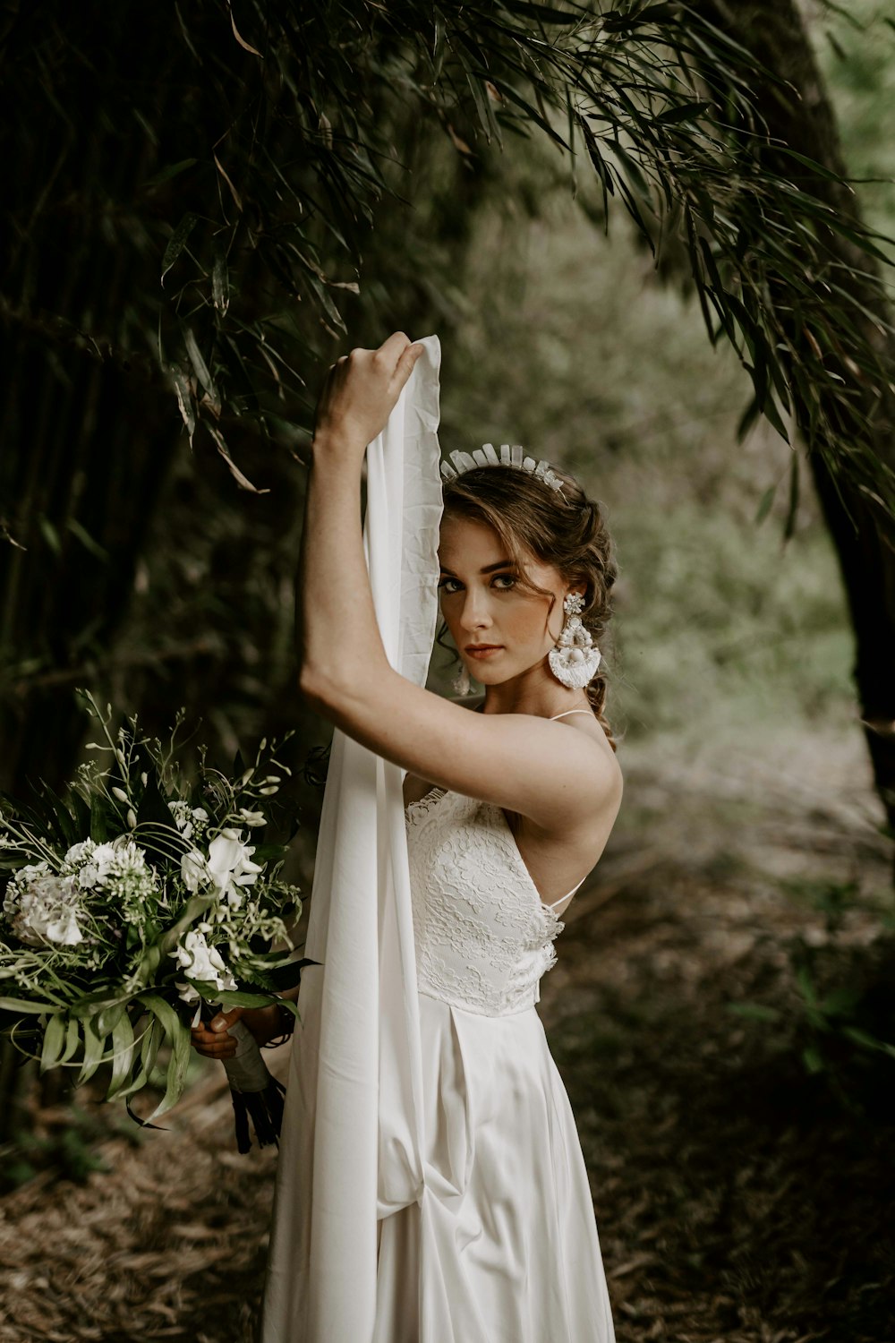 woman wearing white bridal gown across green forest