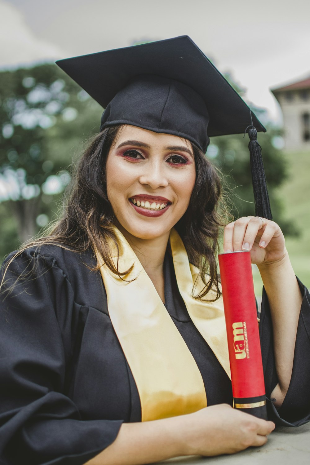 woman wearing black graduation gown holding red tube
