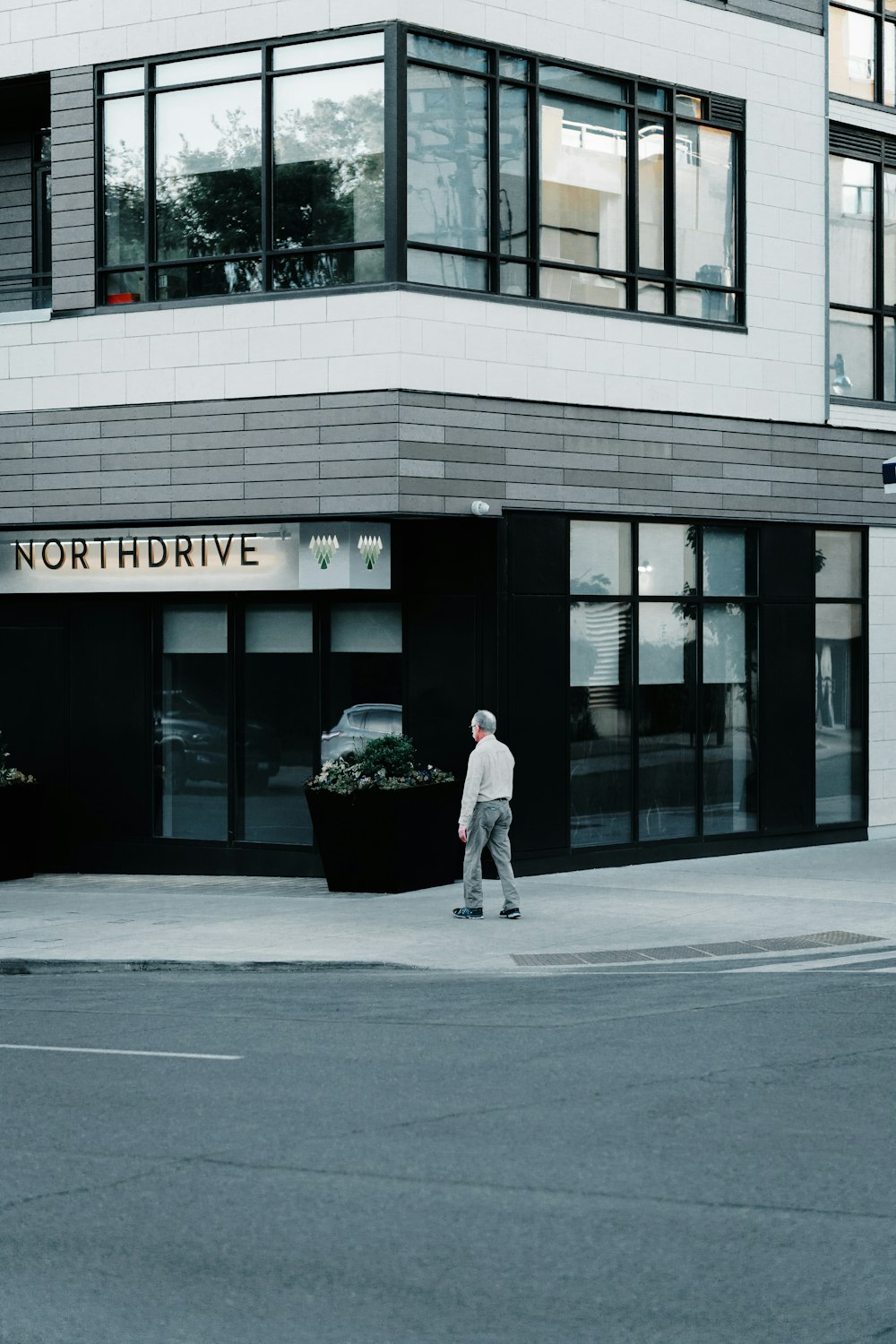 man walking on sidewalk beside building