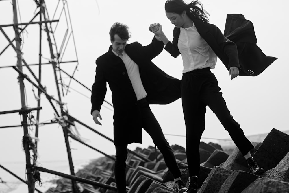 woman and man standing on pile of rocks