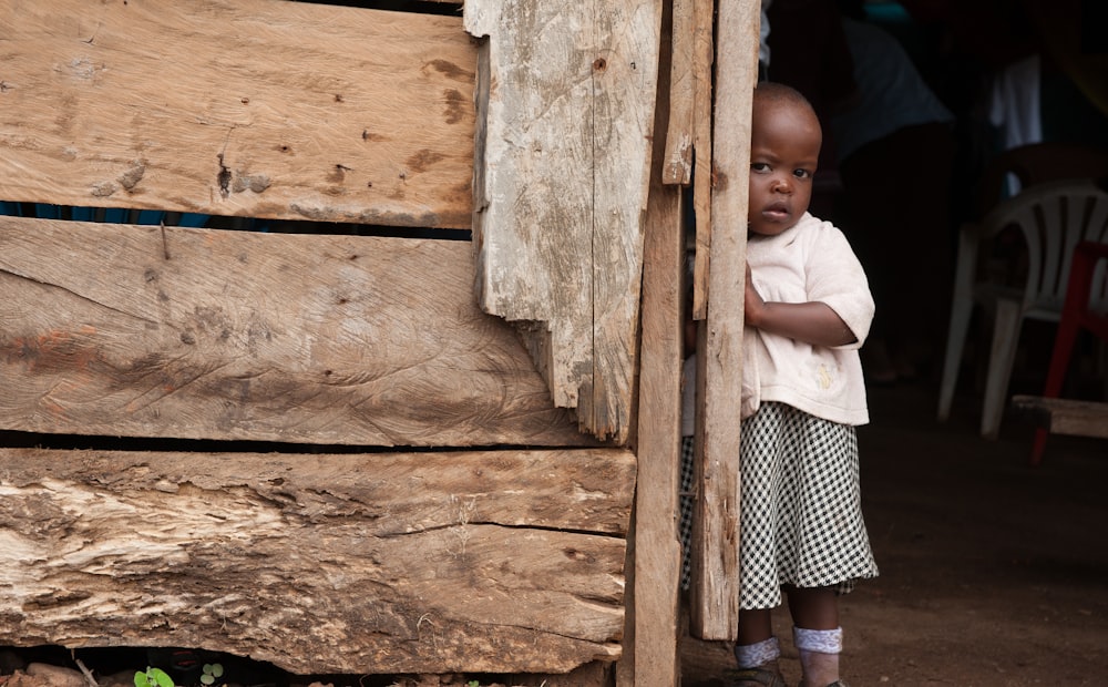 girl standing beside a wooden wall close-up photography