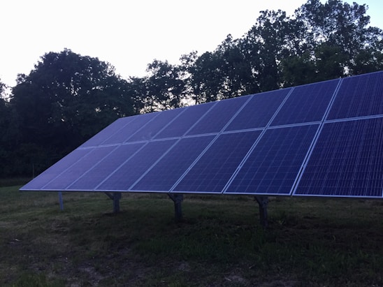 Photo of the MRT Solar Jundiaí team collaborating outdoors with solar panels in the background.
