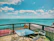 Guests meditating calmly on a wooden deck overlooking turquoise Caribbean waters.