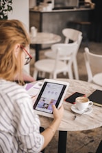 A local salon owner using a tablet to manage their Google Business Profile in a cozy, modern shop.