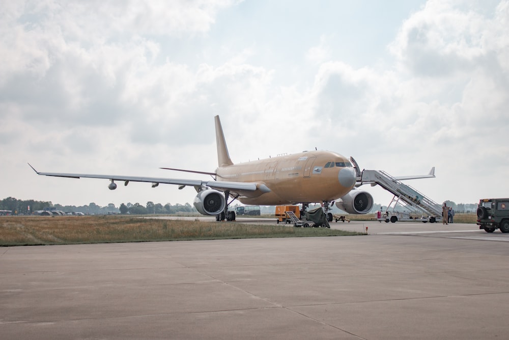 brown and white airplane under cloudy sky