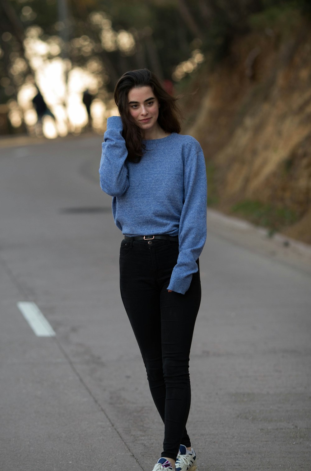 woman wearing blue sweatshirt and black straight-cut jeans \