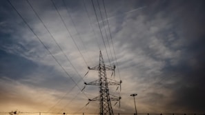silhouette photo of black transmission tower