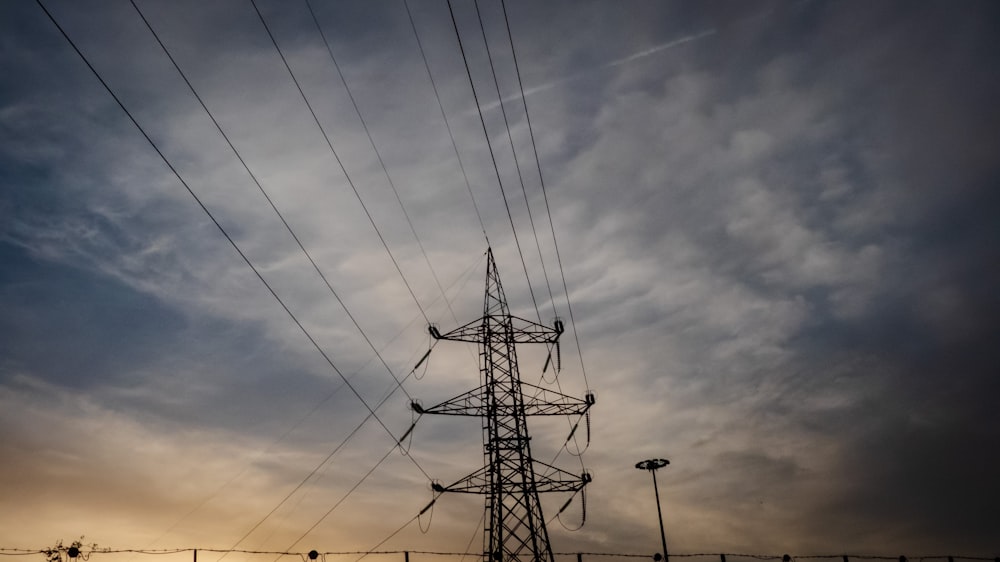 silhouette photo of black transmission tower