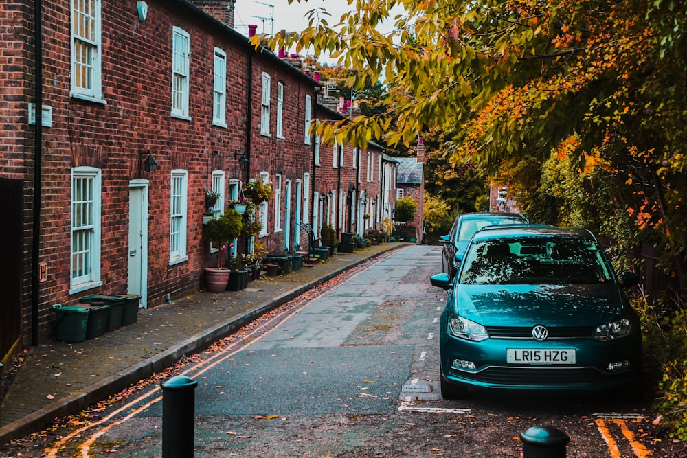 cars parked beside the road near trees and buildings