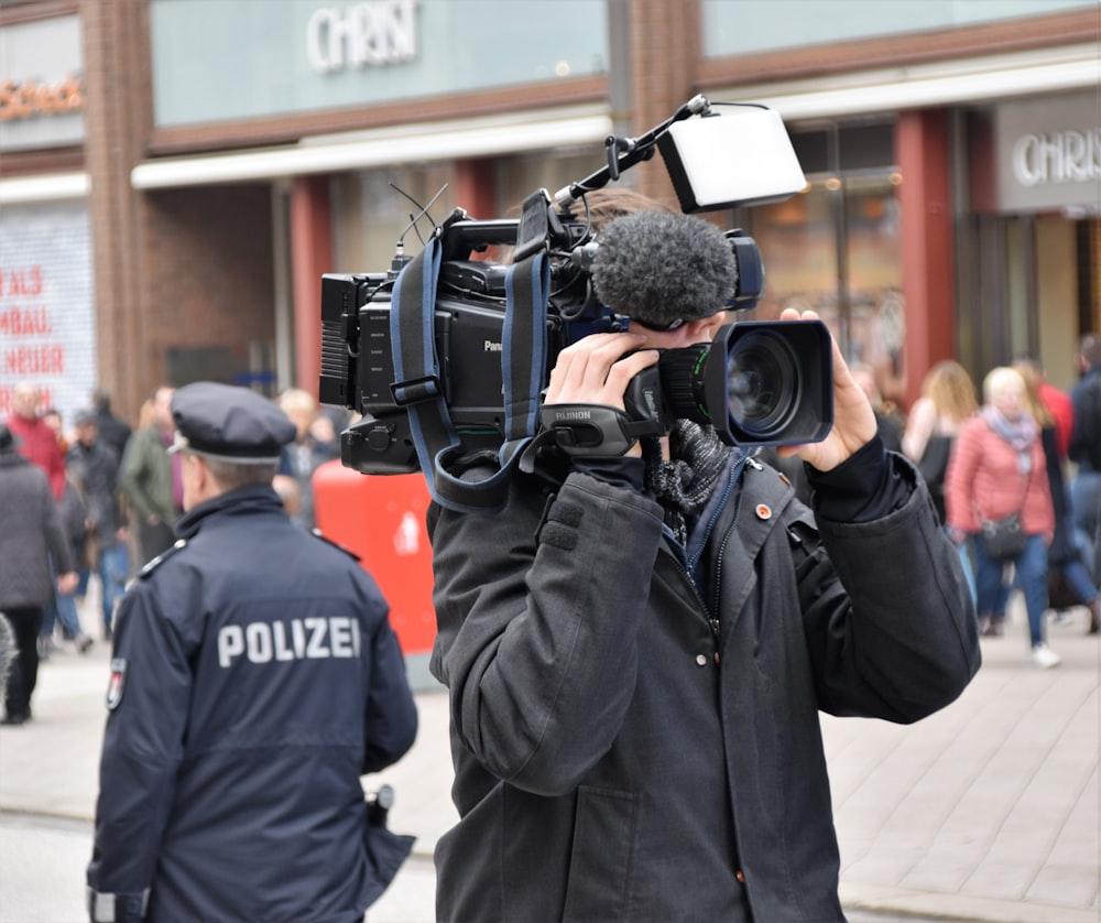 man holding shooting camera