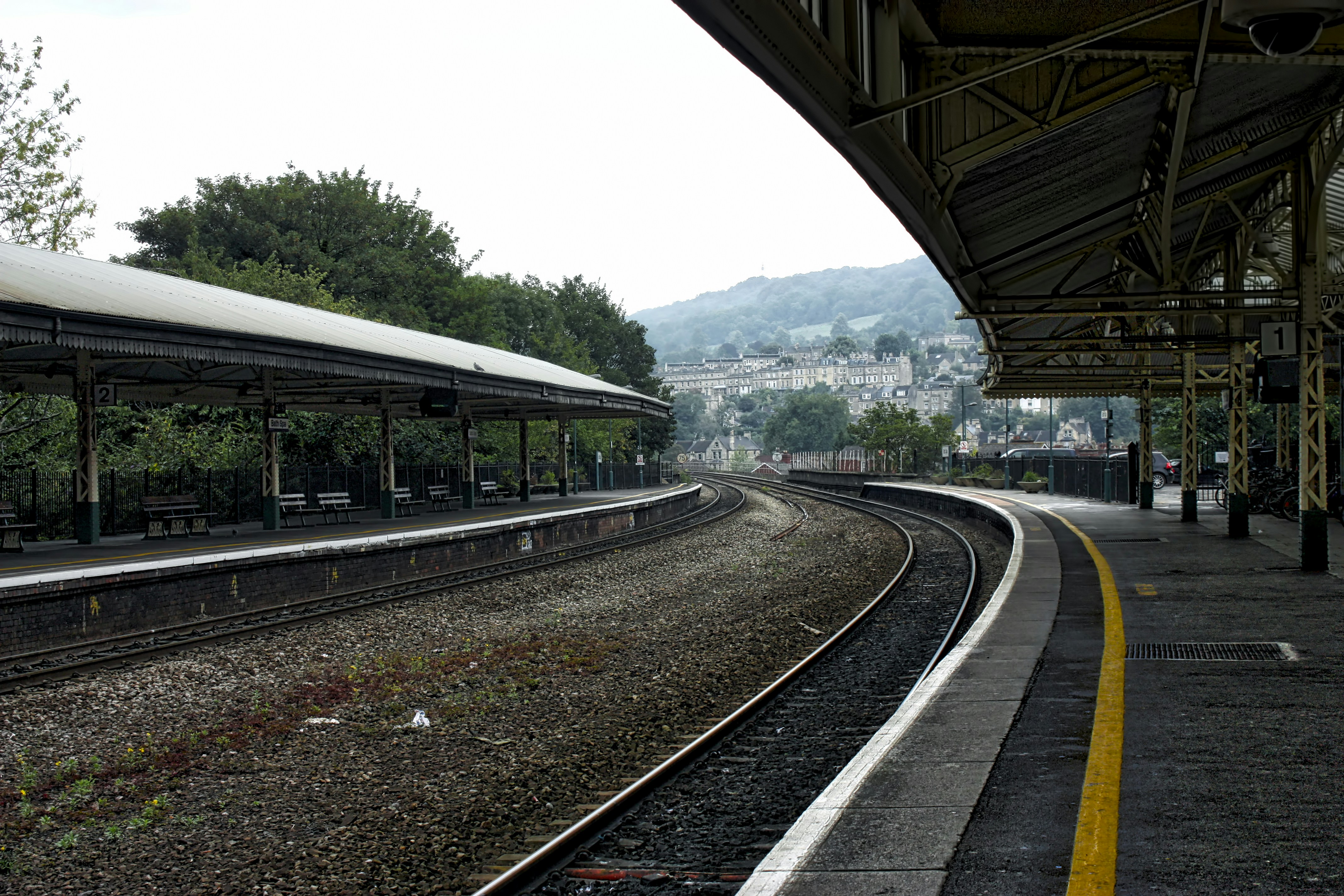 Curved station platform with a yellow safety line beside the tracks