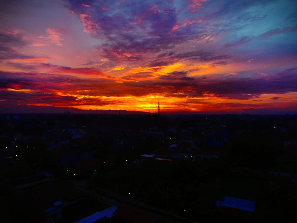 a sunset view of a city with a clock tower in the distance