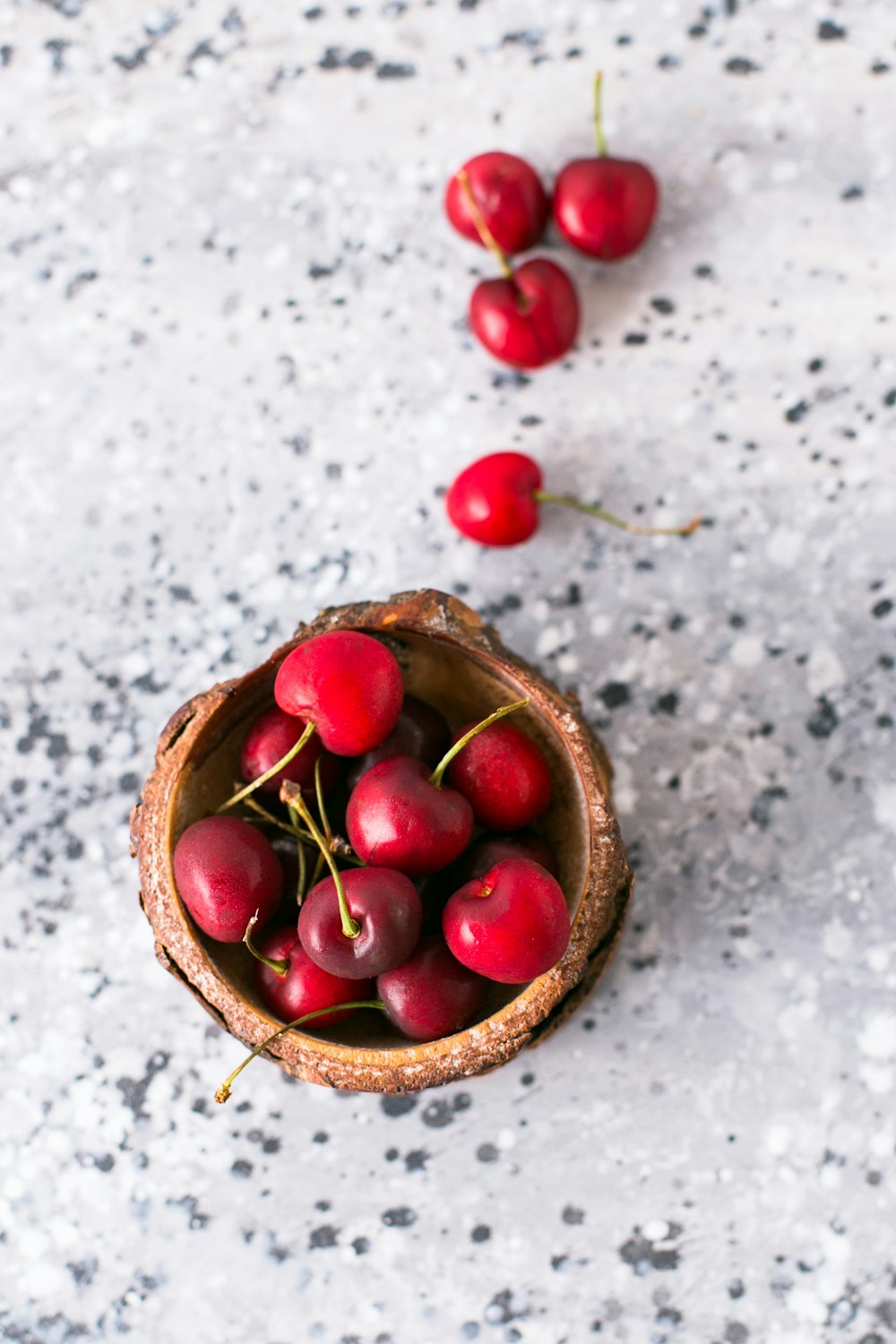 red cherries in brown bowl