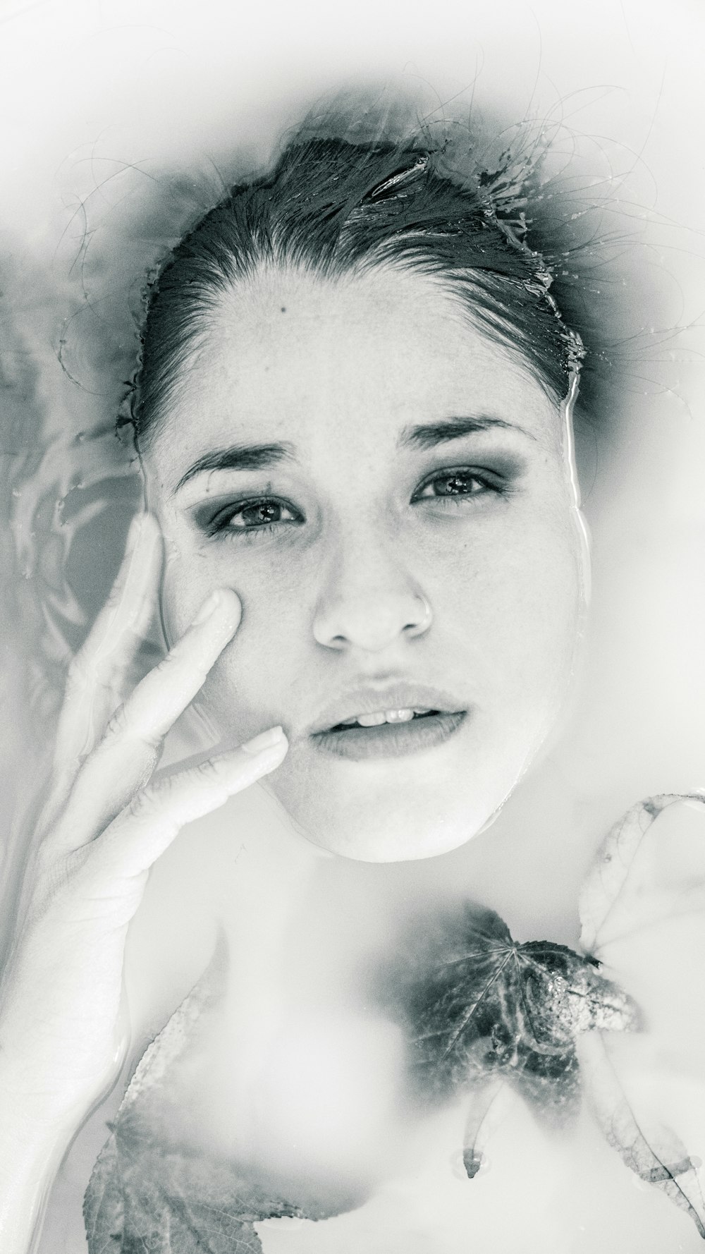 Foto in scala di grigi di donna sdraiata sullo specchio d'acqua