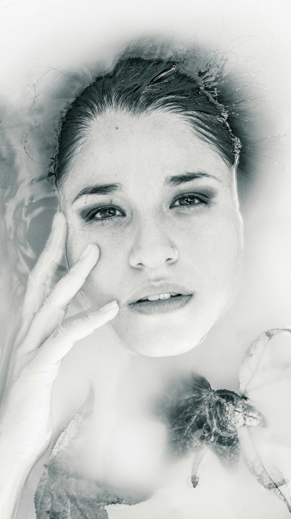 grayscale photo of woman lying on body of water