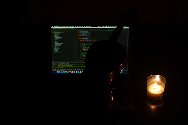 Close-up of hands coding on a laptop, with ancient manuscripts and a candle softly glowing nearby.
