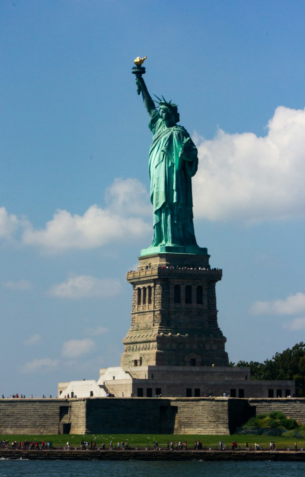 Estátua da Liberdade ao lado de um corpo de água durante o dia