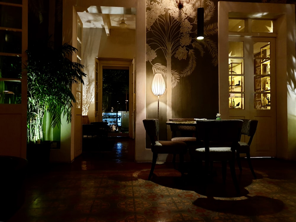 lighted floor lamp near table and chairs