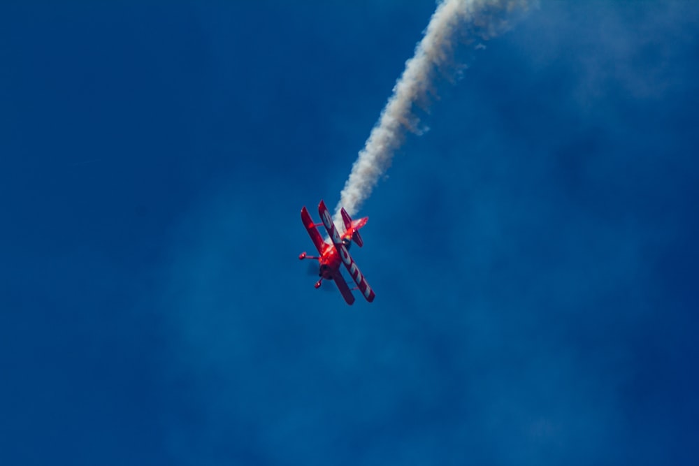 Biplano rojo realizando espectáculo aéreo