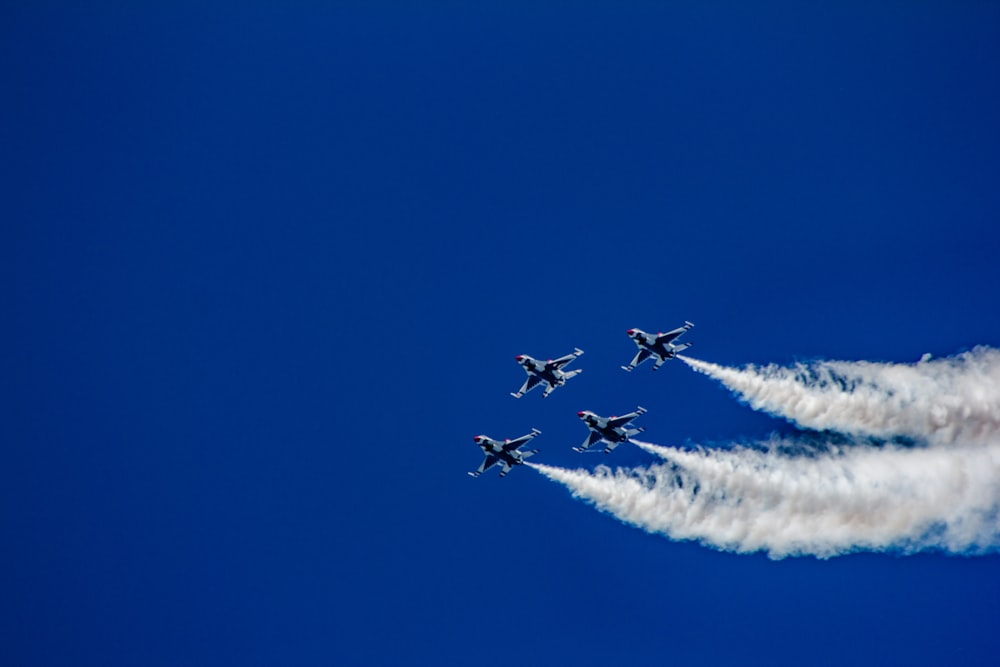 four fighter planes soaring at the sky