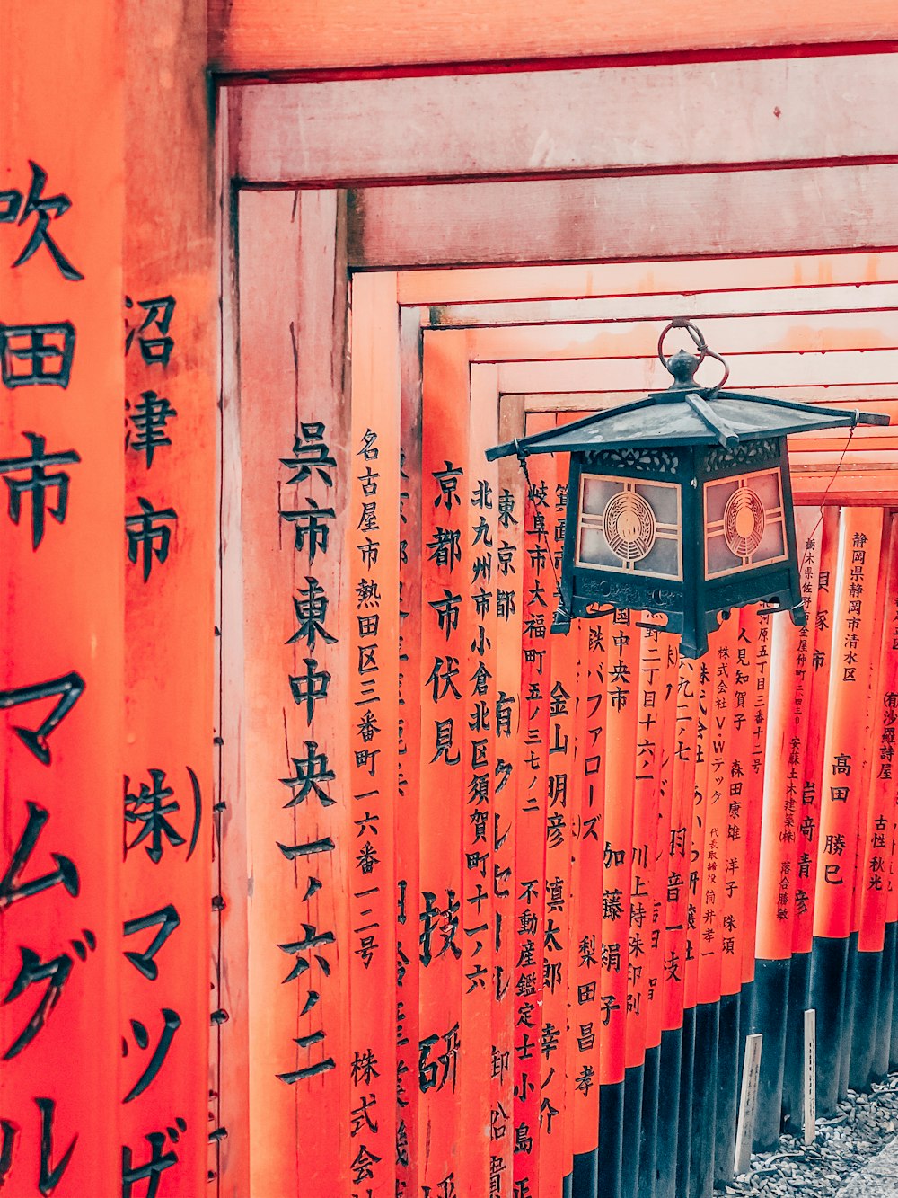 black and brown lantern hanging on orange wooden gate