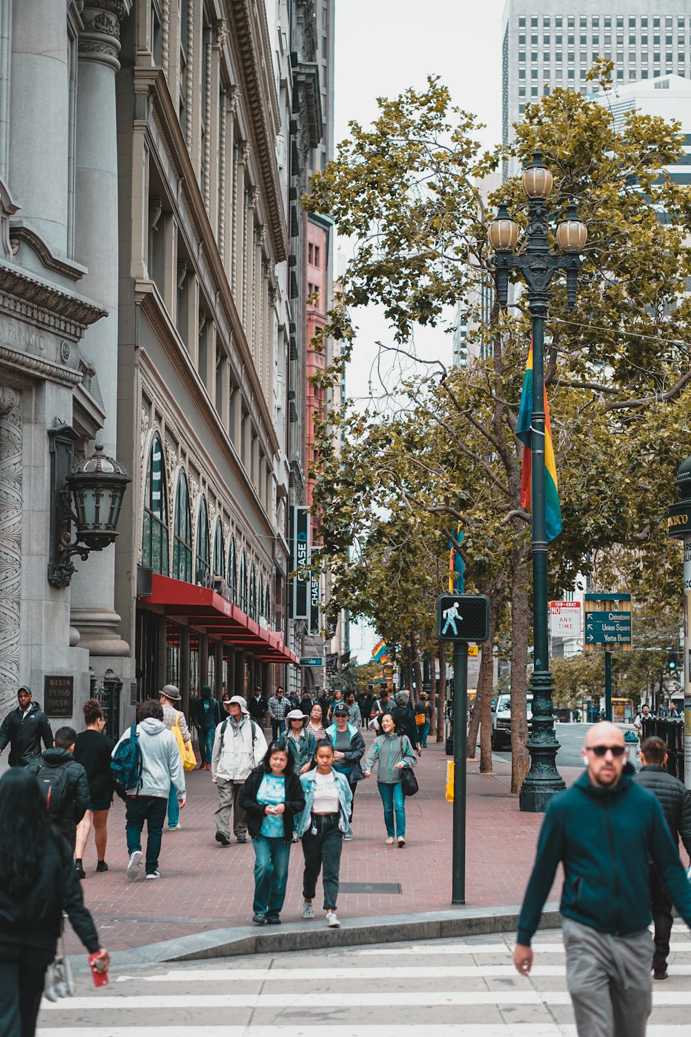 crowd of people walking on sidewalk beside building