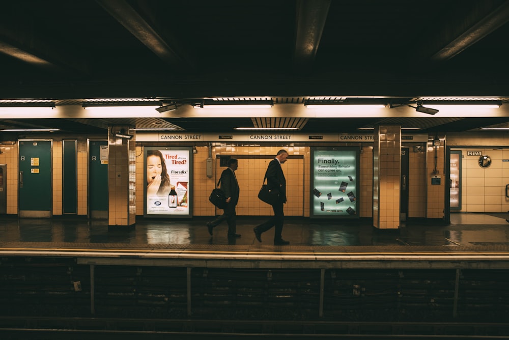 Zwei Männer gehen an der U-Bahn-Station entlang