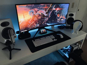 turned on computer monitor with wireless keyboard and mouse