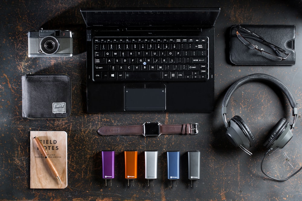 flat lay photography of laptop, headphones, and smartwatch