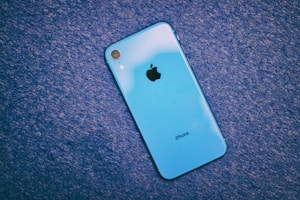 Refurbished iPhone with a deep blue case shown from the side against a white background.
