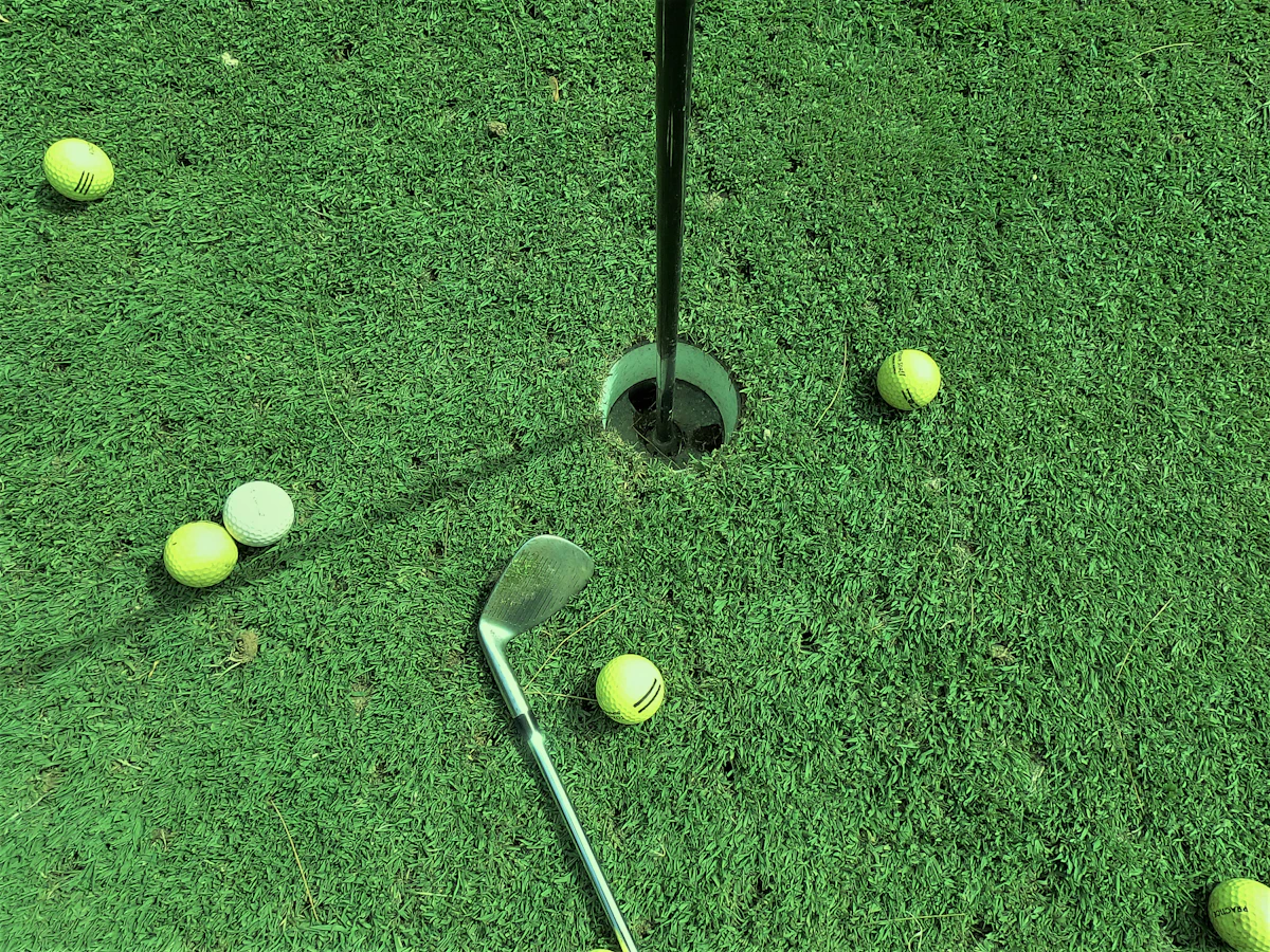 Balles de golf près d'un trou