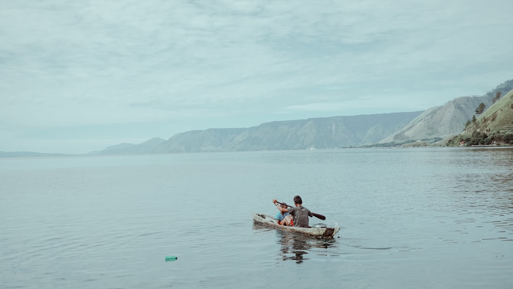 man paddling boat during daytime