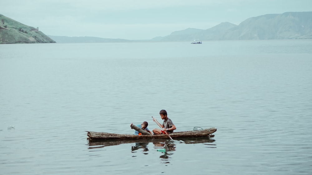 two person paddling on boat on sea