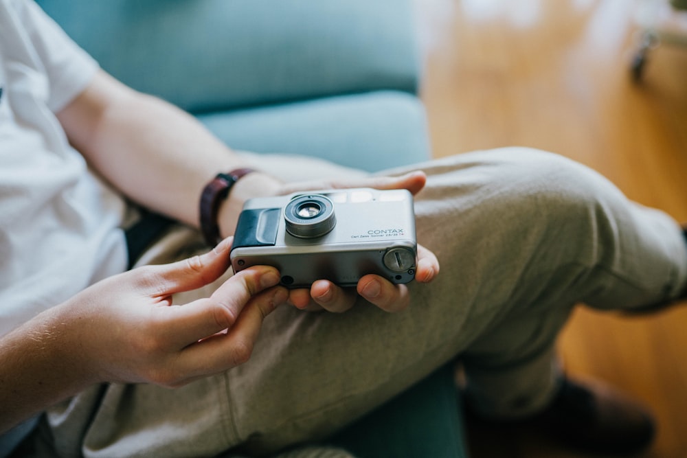 person holding grey SLR camera