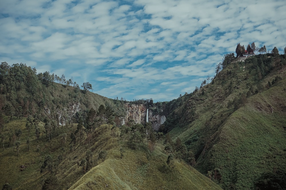 mountain under white clouds and blue sky during daytime