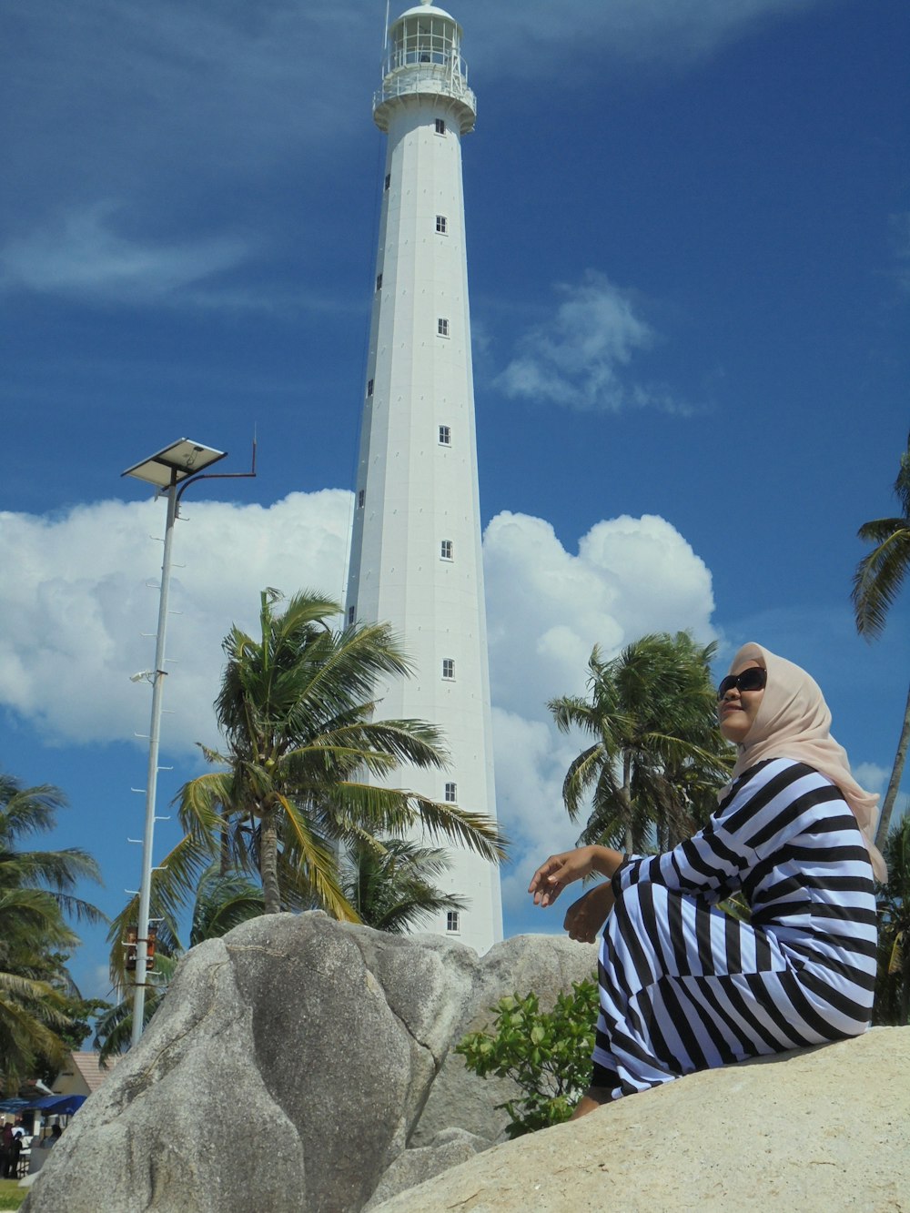 woman standing beside lighthouse