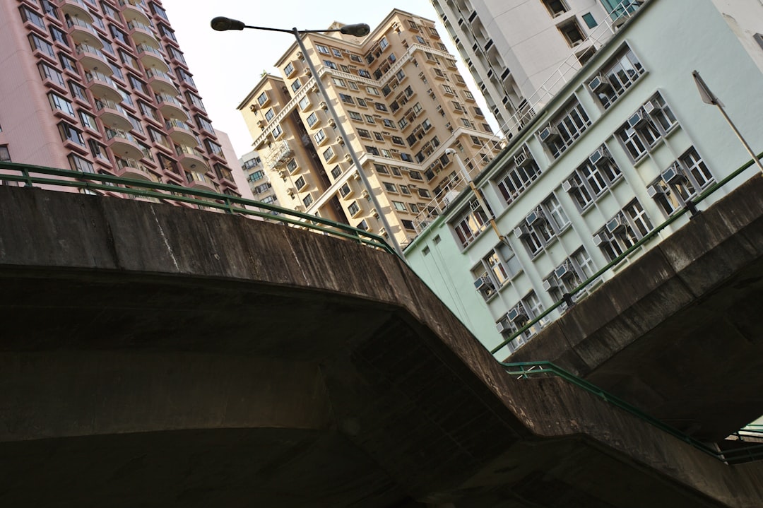 concrete bridge near buildings during day