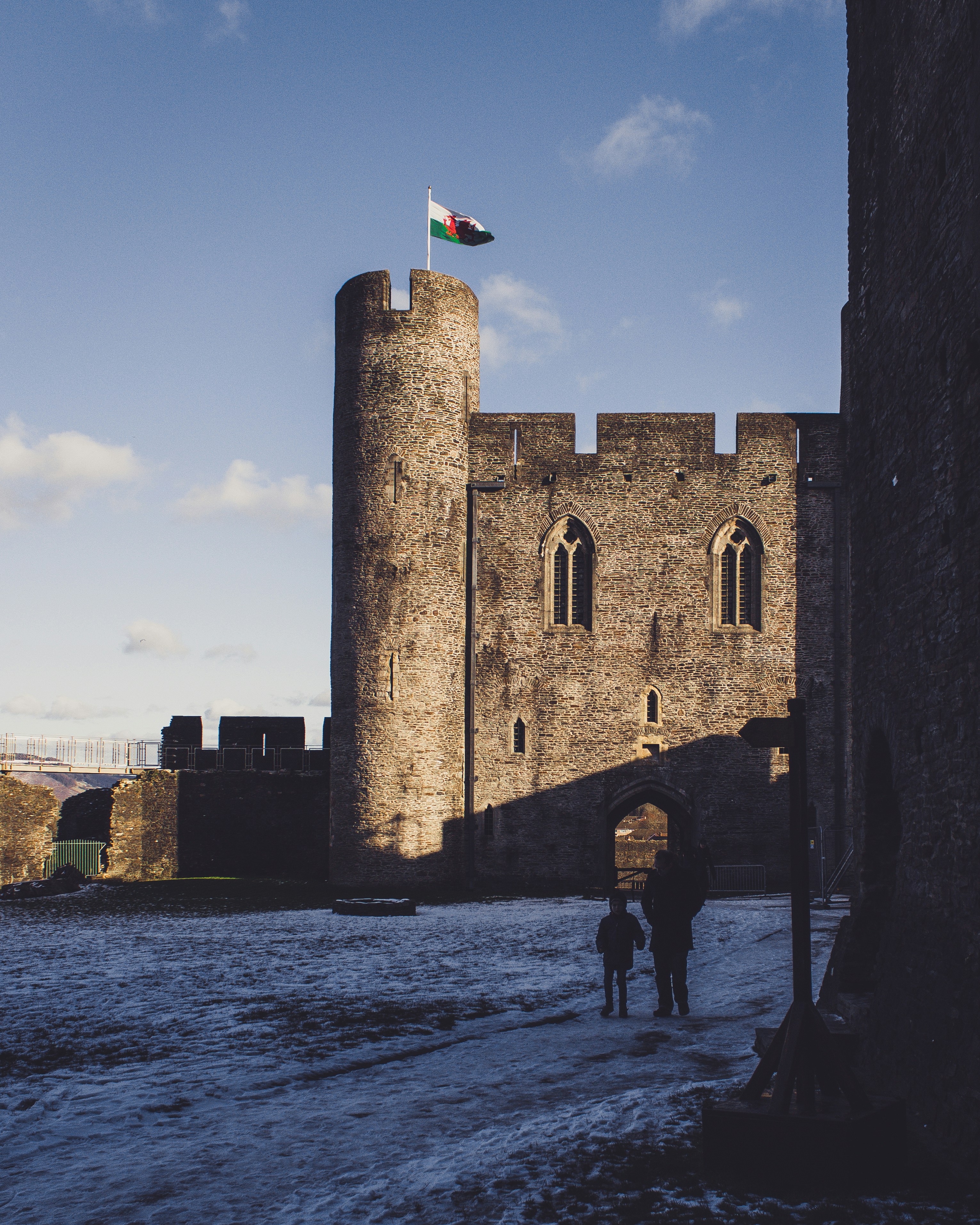 two person standing beside gray concrete building with flag during daytime