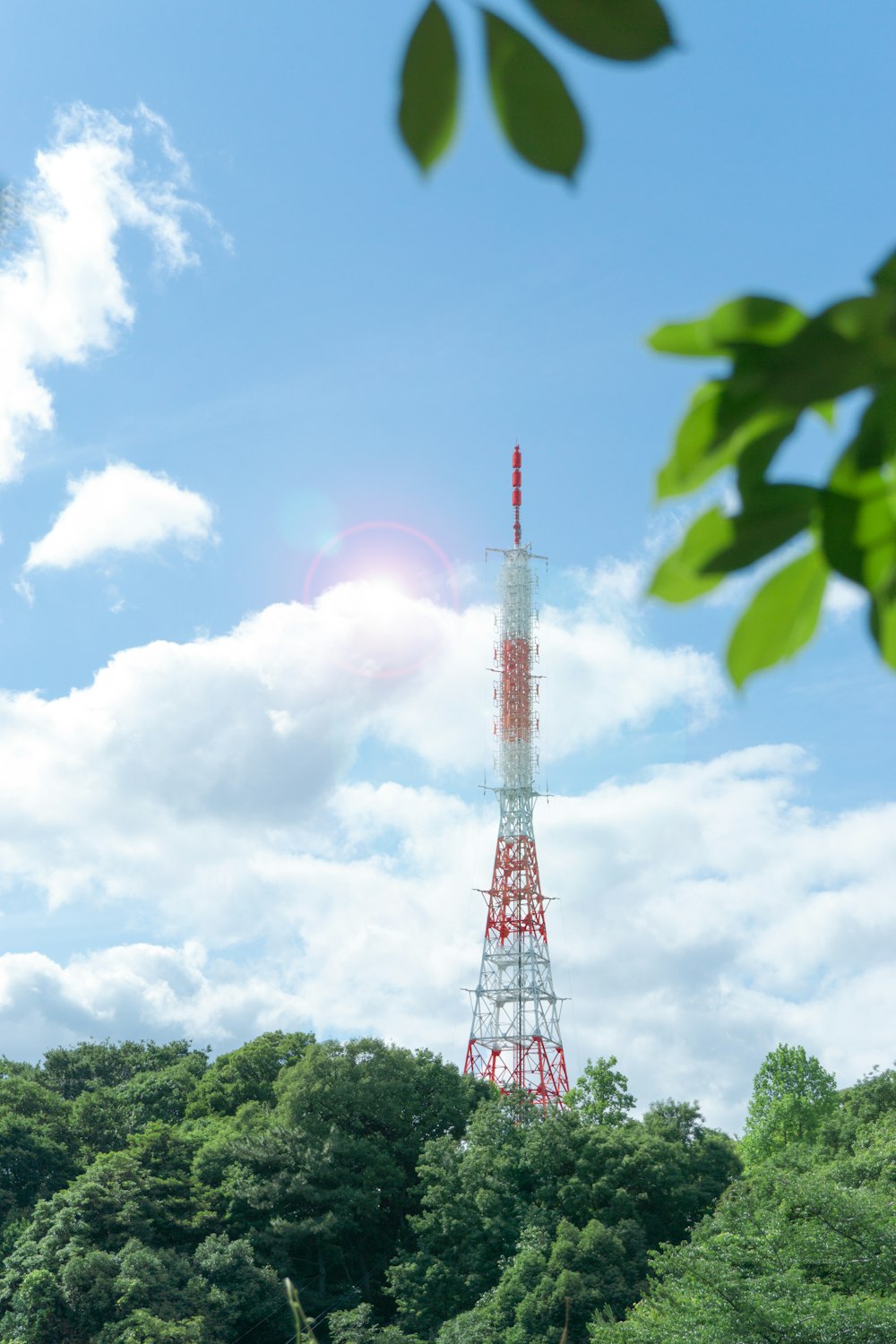 red and white metal tower near trees during day